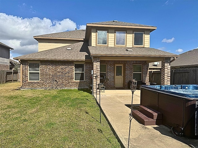 rear view of property with a patio area, a hot tub, fence, and brick siding