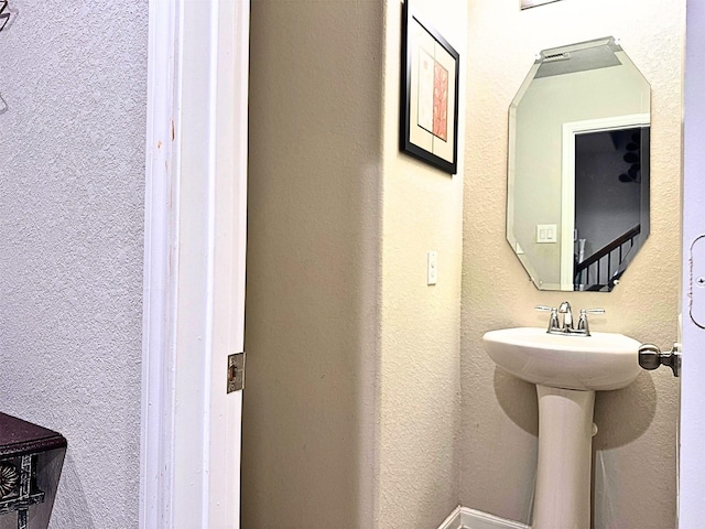 bathroom with a textured wall and a sink