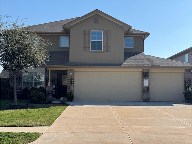 traditional-style house with brick siding, a front yard, concrete driveway, and stucco siding