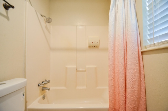 bathroom with shower / bath combo with shower curtain and toilet