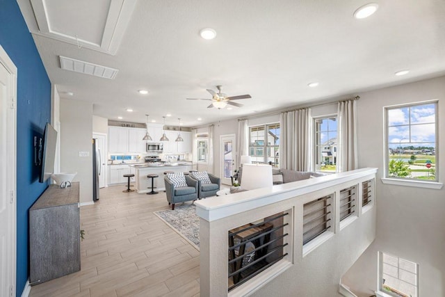 living room featuring ceiling fan and light wood-type flooring