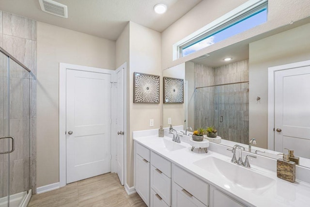 bathroom with a shower with door and vanity