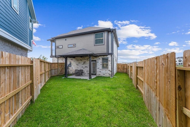 rear view of house with a lawn and a patio