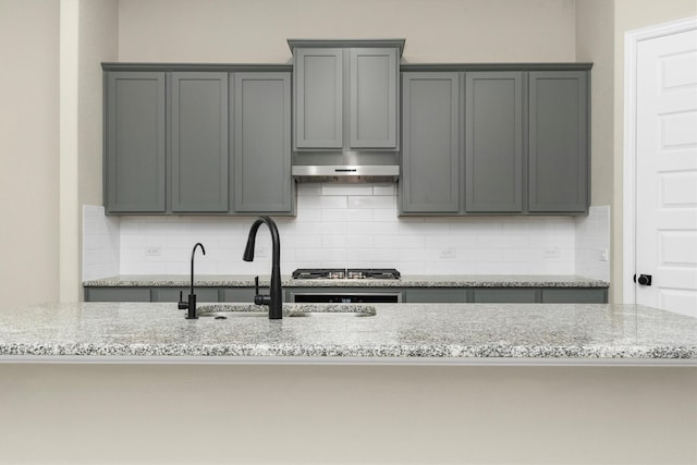 kitchen featuring gray cabinetry and light stone countertops