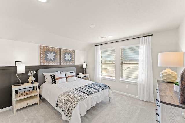 bedroom featuring light colored carpet and lofted ceiling