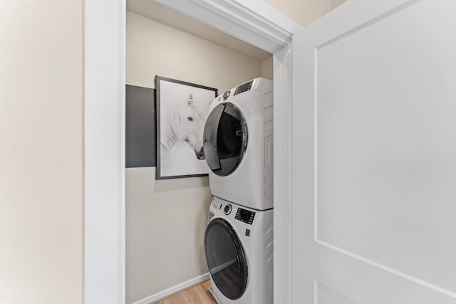 washroom featuring stacked washer / dryer and wood-type flooring