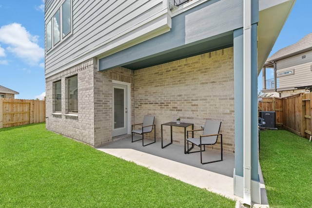 rear view of house featuring a lawn, cooling unit, and a patio area