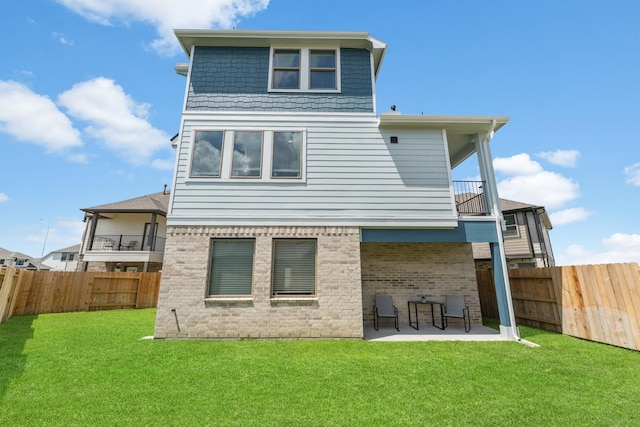 back of house featuring a patio, a balcony, and a lawn