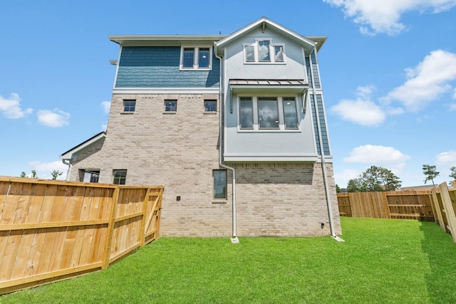 back of house with a lawn