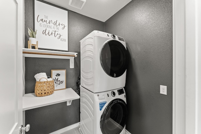 clothes washing area with stacked washer and dryer