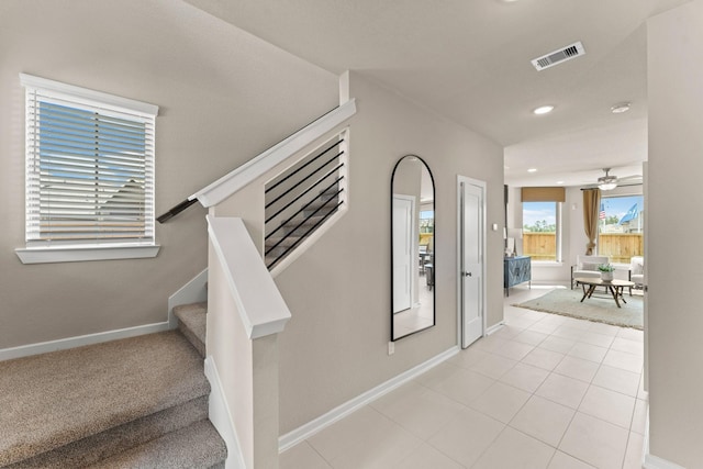 stairs with tile patterned floors and ceiling fan