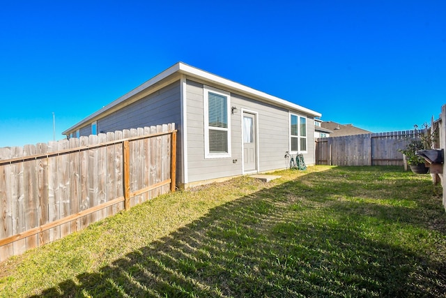 view of side of home with a yard