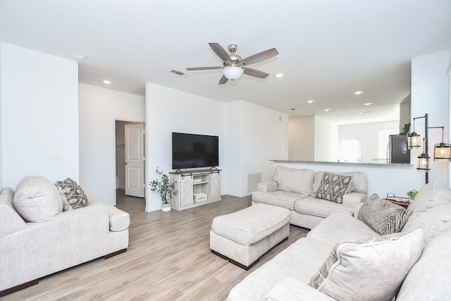 living room featuring light wood-type flooring and ceiling fan