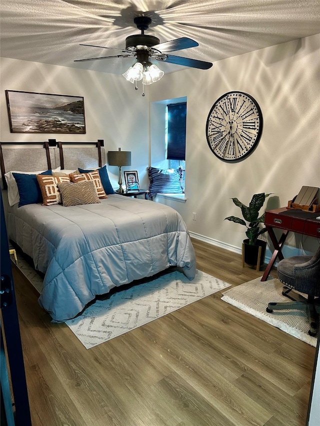 bedroom featuring ceiling fan, hardwood / wood-style floors, and a textured ceiling