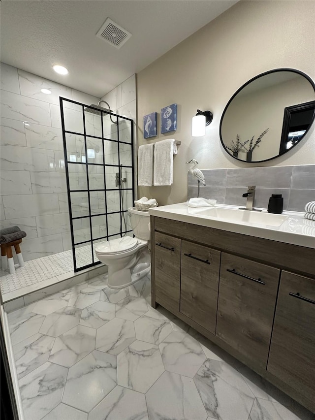 bathroom with vanity, toilet, and a tile shower