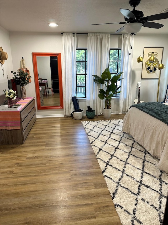 bedroom with ceiling fan and hardwood / wood-style floors