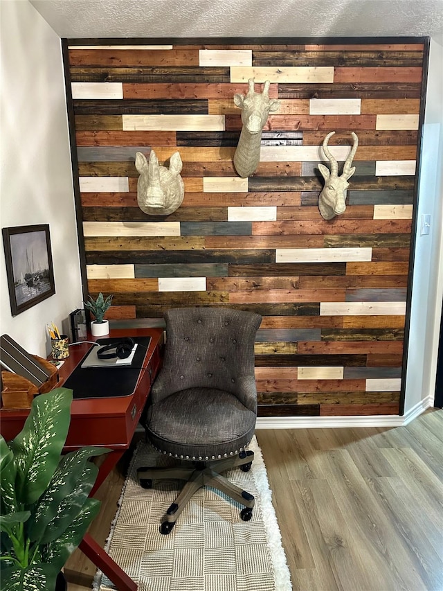 interior space with hardwood / wood-style floors, wood walls, and a textured ceiling