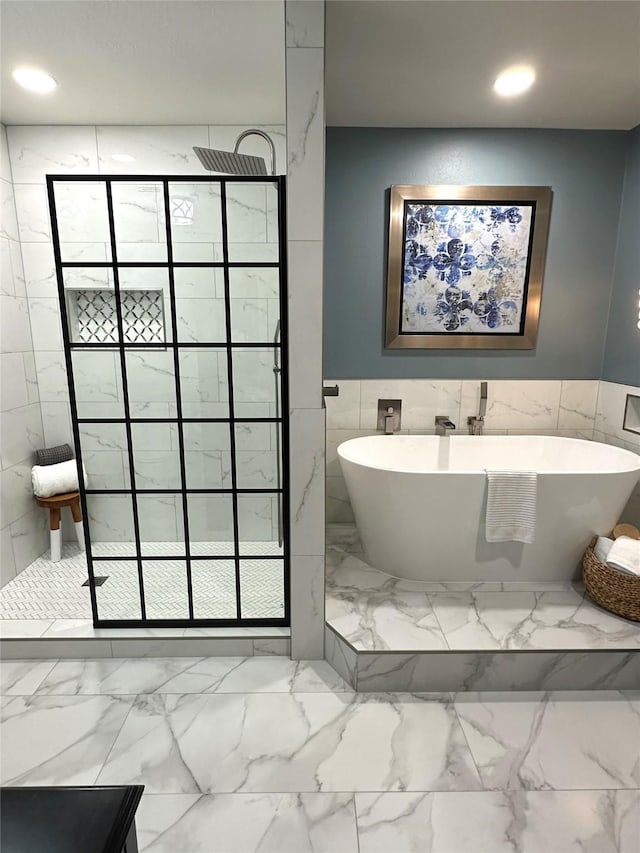 bathroom featuring tile walls and independent shower and bath