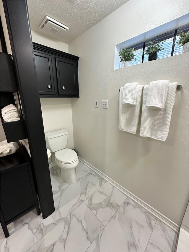 bathroom with a textured ceiling and toilet