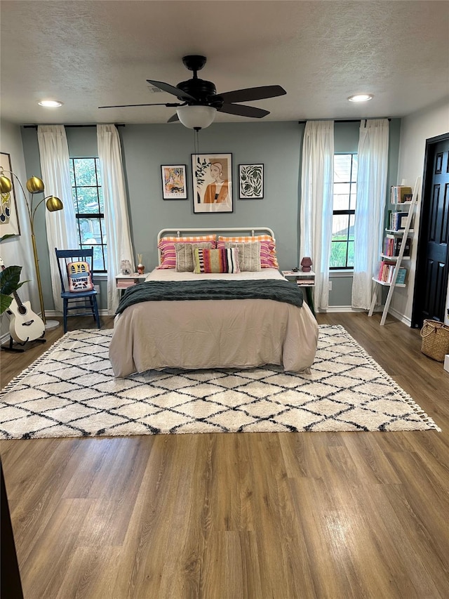 bedroom featuring ceiling fan, a textured ceiling, and hardwood / wood-style flooring