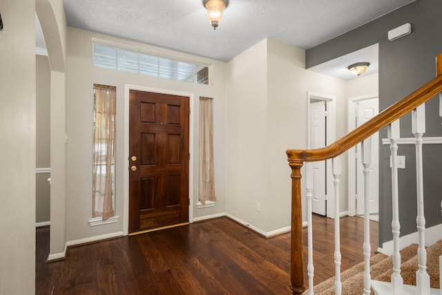 entrance foyer with dark hardwood / wood-style flooring and a textured ceiling