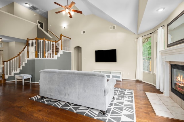 living room with ceiling fan, a fireplace, high vaulted ceiling, and hardwood / wood-style floors