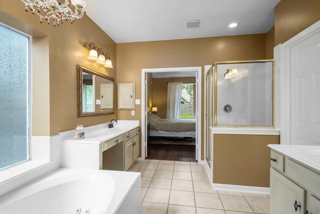 bathroom featuring tile patterned flooring, vanity, independent shower and bath, and a chandelier