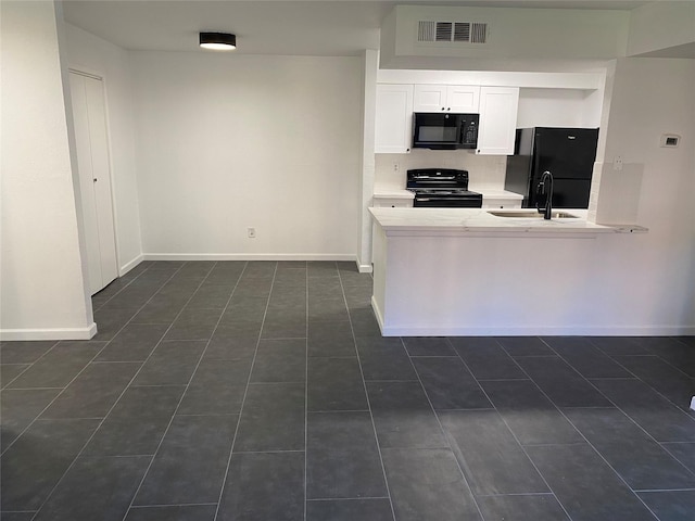 kitchen featuring sink, backsplash, white cabinets, black appliances, and dark tile patterned flooring