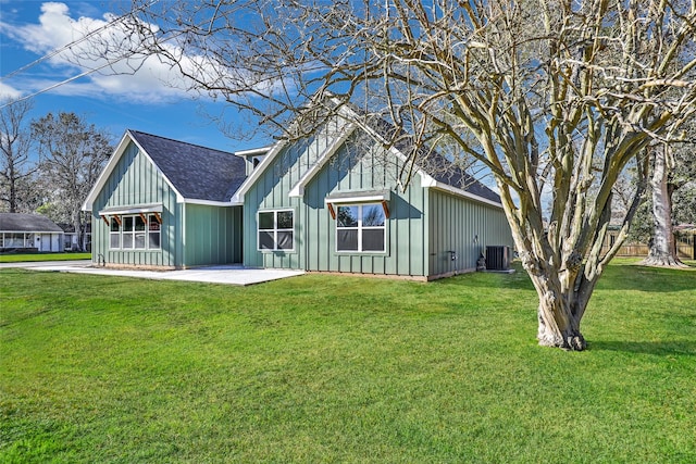 rear view of house with covered porch, central AC, and a lawn