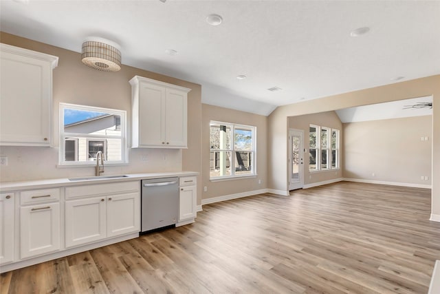 kitchen featuring dishwasher, sink, light hardwood / wood-style flooring, vaulted ceiling, and white cabinets