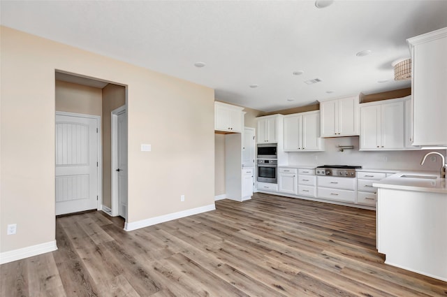 kitchen with white cabinetry, sink, stainless steel appliances, and light wood-type flooring