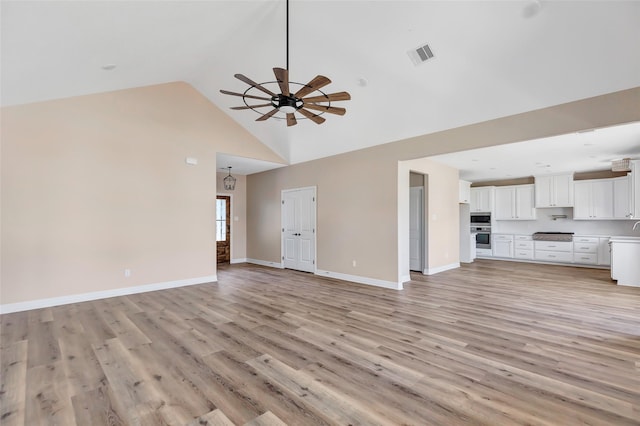 unfurnished living room with ceiling fan, high vaulted ceiling, and light hardwood / wood-style floors