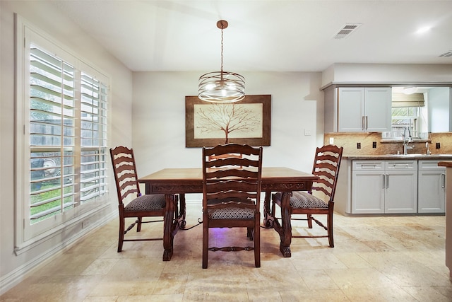 dining space with sink, a chandelier, and plenty of natural light