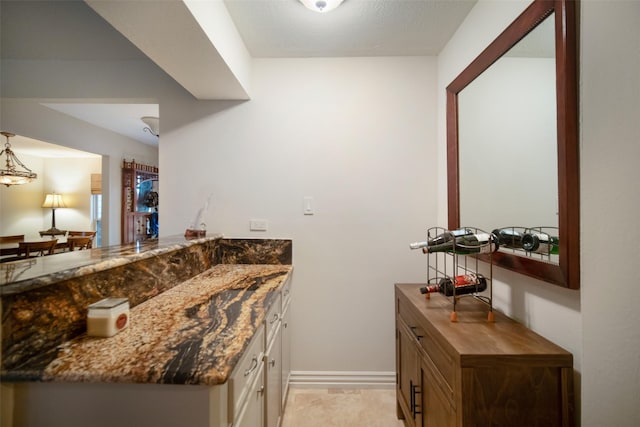 interior space with dark stone countertops and kitchen peninsula