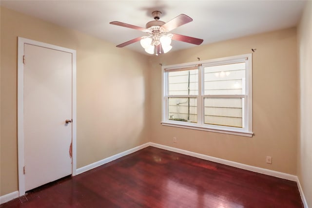 spare room with dark hardwood / wood-style flooring and ceiling fan