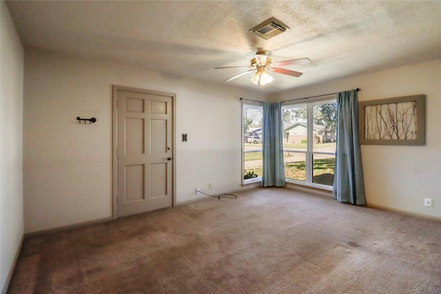 carpeted empty room with ceiling fan and a textured ceiling