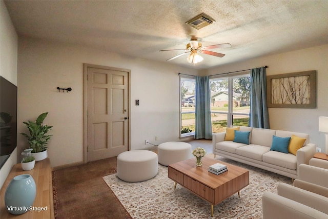 living room with ceiling fan and a textured ceiling