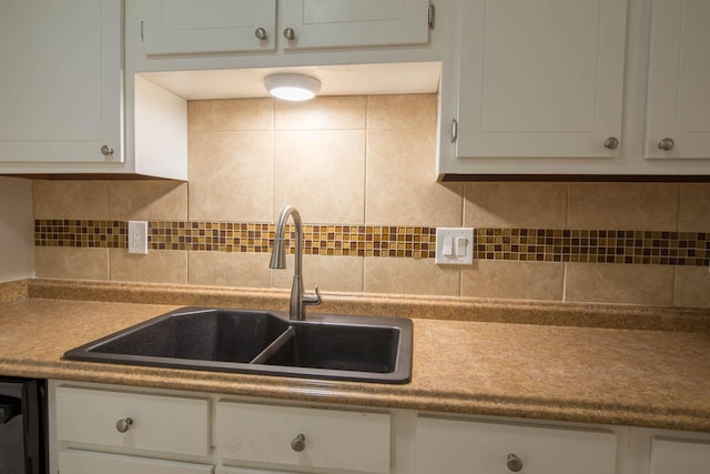 kitchen with sink, dishwasher, white cabinetry, and decorative backsplash