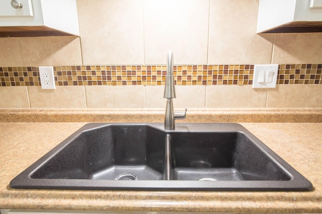 interior details featuring sink and white cabinets