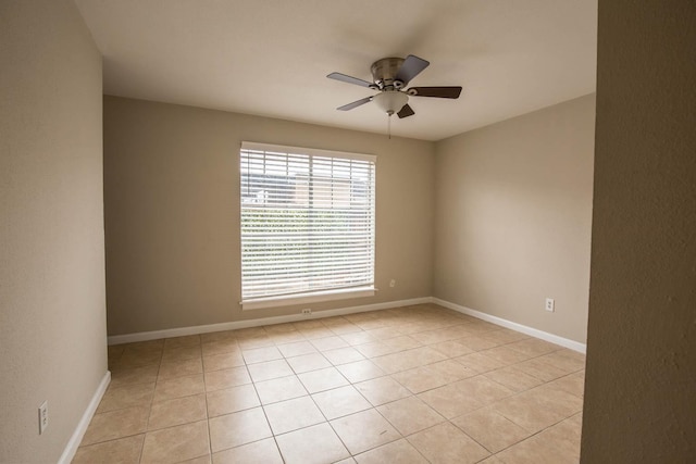 empty room with ceiling fan and light tile patterned floors