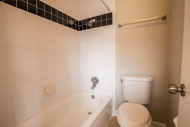 bathroom with toilet and tiled shower / bath combo