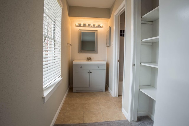 bathroom with built in features, vanity, and tile patterned flooring