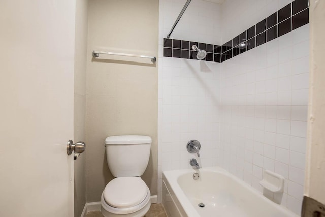 bathroom featuring toilet and tiled shower / bath