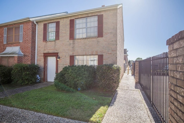 townhome / multi-family property featuring a front lawn