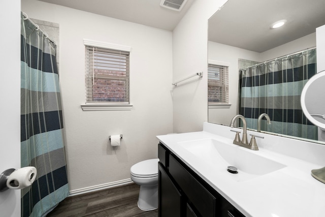 bathroom featuring vanity, hardwood / wood-style flooring, toilet, and curtained shower