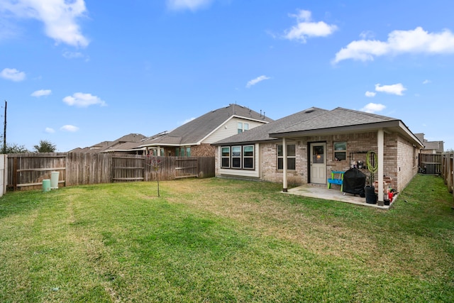 back of house with a yard and a patio