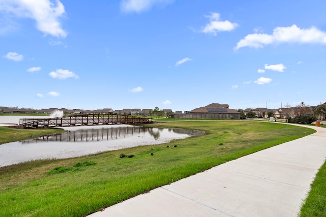 view of community featuring a lawn and a water view