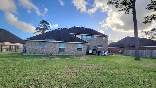 rear view of property featuring a lawn