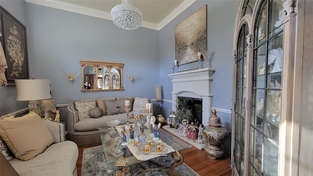 living room with a chandelier, wood-type flooring, and ornamental molding