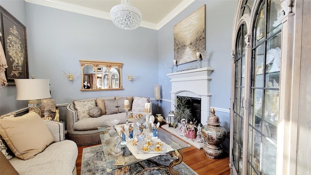 living room with hardwood / wood-style flooring, ornamental molding, and a chandelier